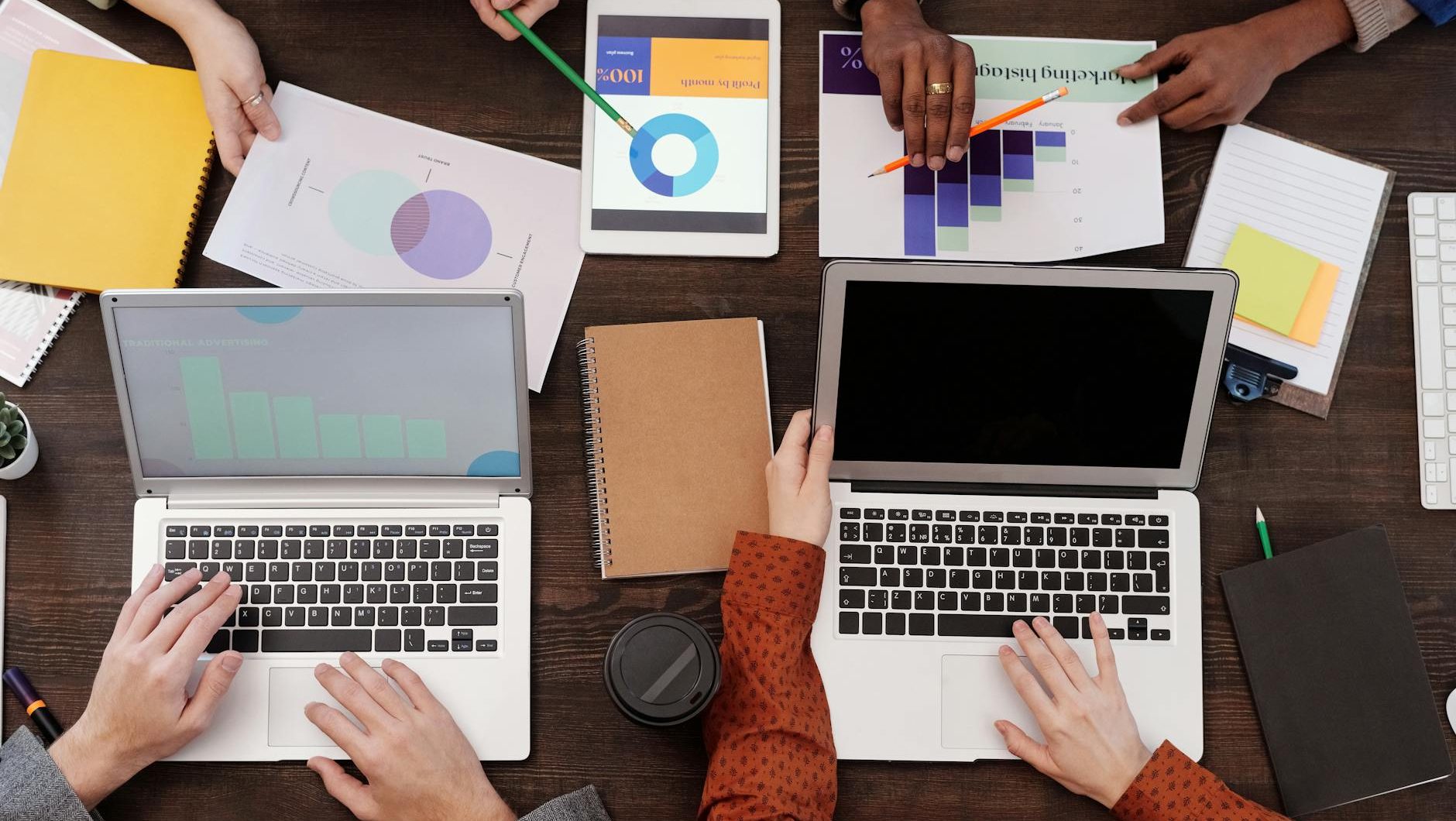 a group of people with graphs and pie charts on table