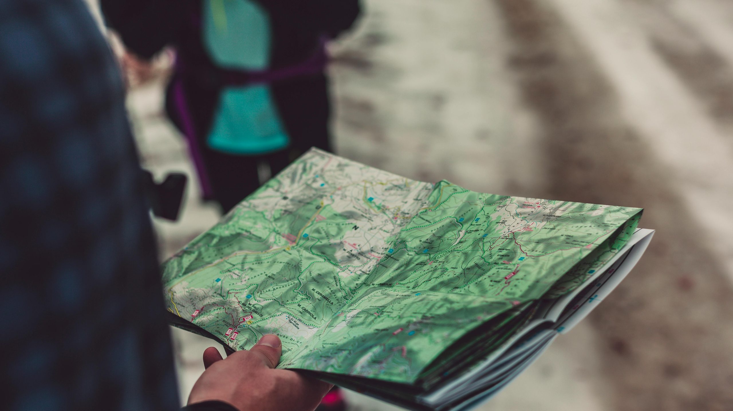 A close-up of a person holding a detailed route map outdoors, ideal for travel and exploration themes.